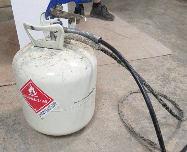 White tank with a spray nozzle containing flammable glue