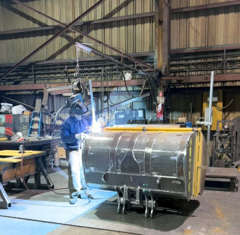 Photo of Young Corporation employee welding with his welding helmet up, so he had no protection for his eyes against the welding rays.